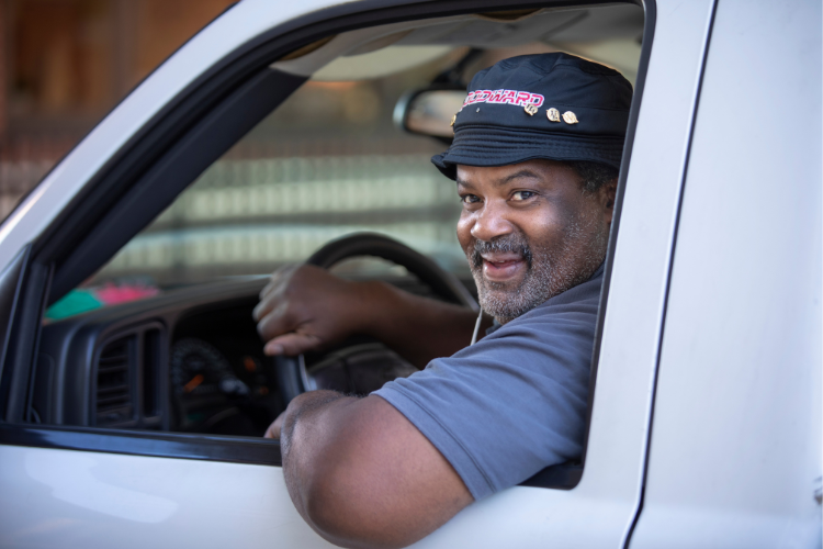 Woodward Academy van driver smiling while wearing a Woodward hat